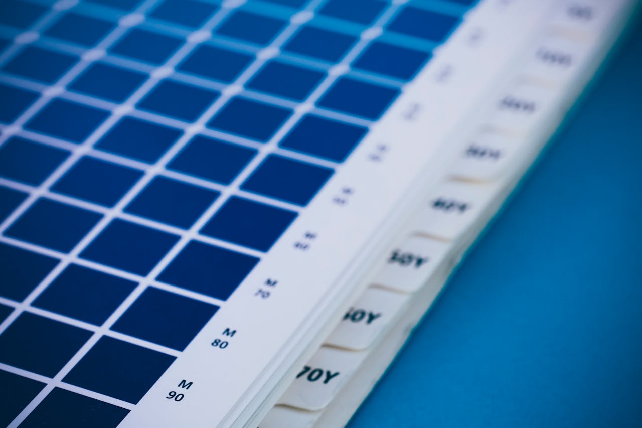 Close-up of a blue color swatch book showing different shades and codes.