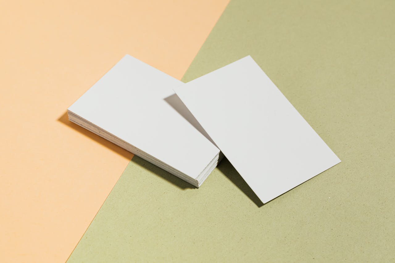 Stack of blank white business cards on pastel surface offering copy space for design.